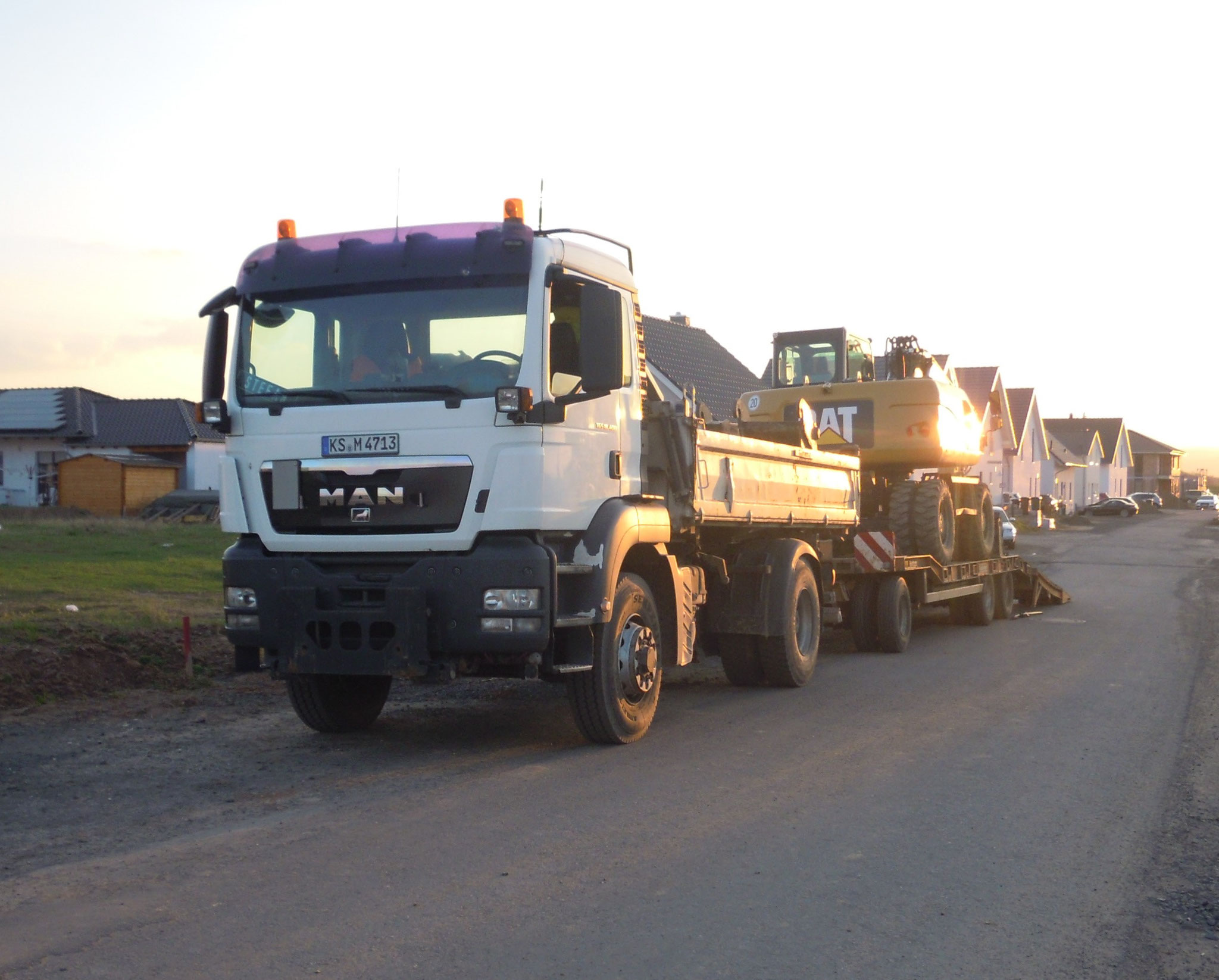 Hammerlindl Tieflader mit Baumaschine bei Sonnenuntergang